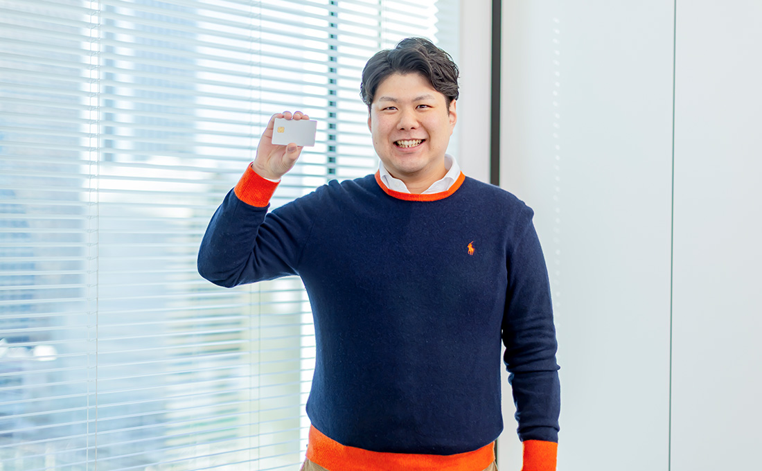 ファミマカードを持って笑顔の早川さんの写真